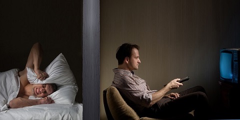 Man at night can't fall asleep because of the noisy neighbor