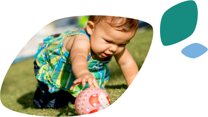 A crawling toddler is reaching for a red and white ball