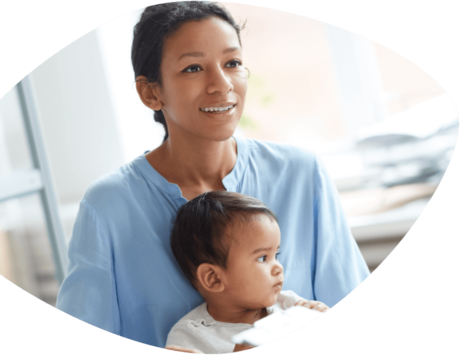 Smiling young mother is gazing forward while the small boy on her lap looks to the side