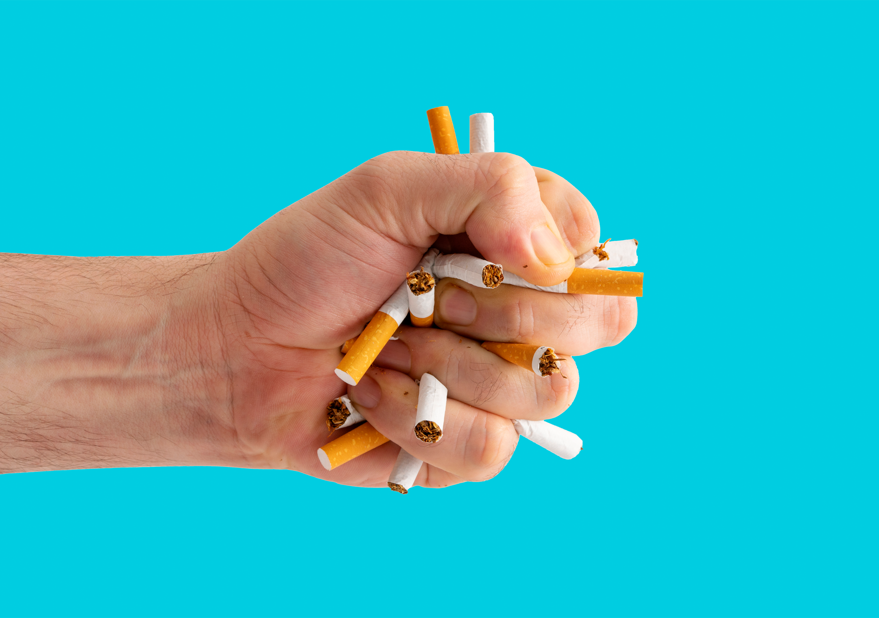 Hand clutching cigarettes in a closed fist
