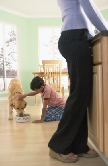 child petting dog while eating